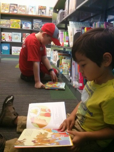 Two kids reading the same book