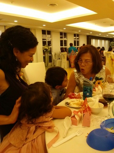 Flying kiss for grandma at Malacca wedding dinner